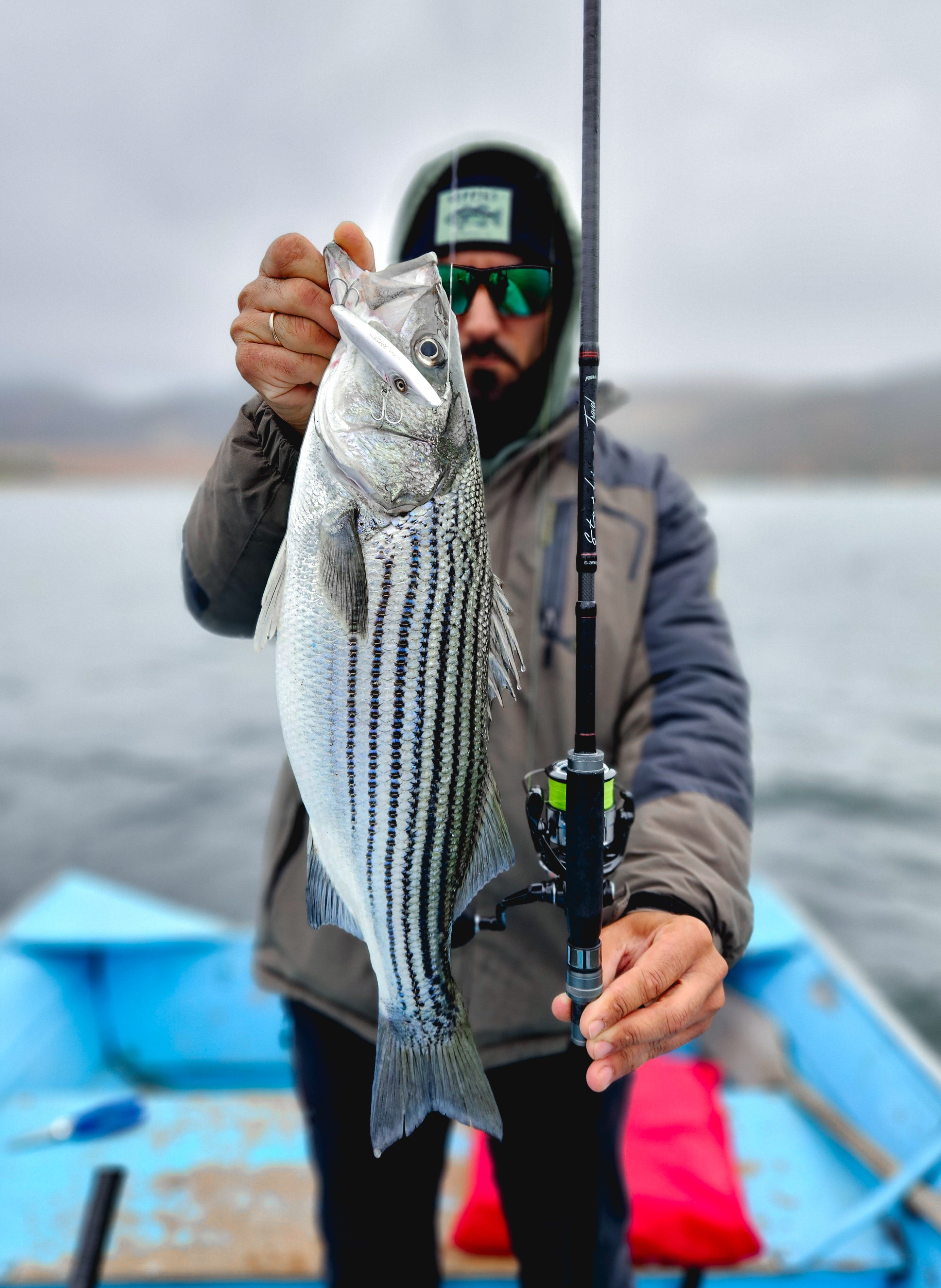 Raul holding a striped bass caught with an Espetit lure